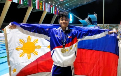 <p><strong>WINNER.</strong> Jamesray Mishael Ajido holds the Philippine flag after winning the boys’ 12-14 100m butterfly event in the 11th Asian Age Group Championships at New Clark City Aquatics Center in Capas, Tarlac on Feb. 28, 2024. Ajido, together with Mishka Sy, ruled their respective categories at the start of the three-day Philippine Aquatics, Inc. National Age Group Championships at the Teofilo Yldefonso Swimming Pool inside the Rizal Memorial Sports Complex in Manila on Friday (June 21). <em>(PNA photo by Jean Malanum) </em></p>