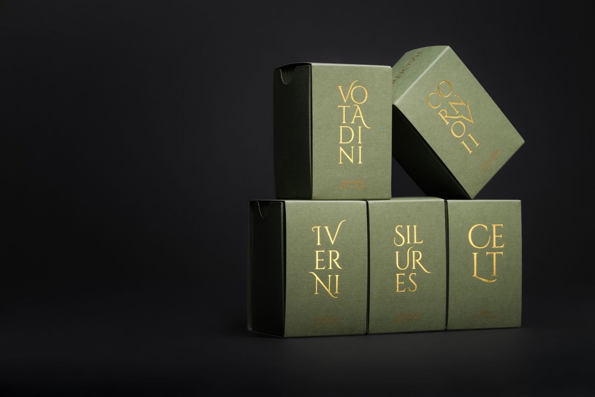 深色背景前，数个绿色香水盒堆叠在一起。